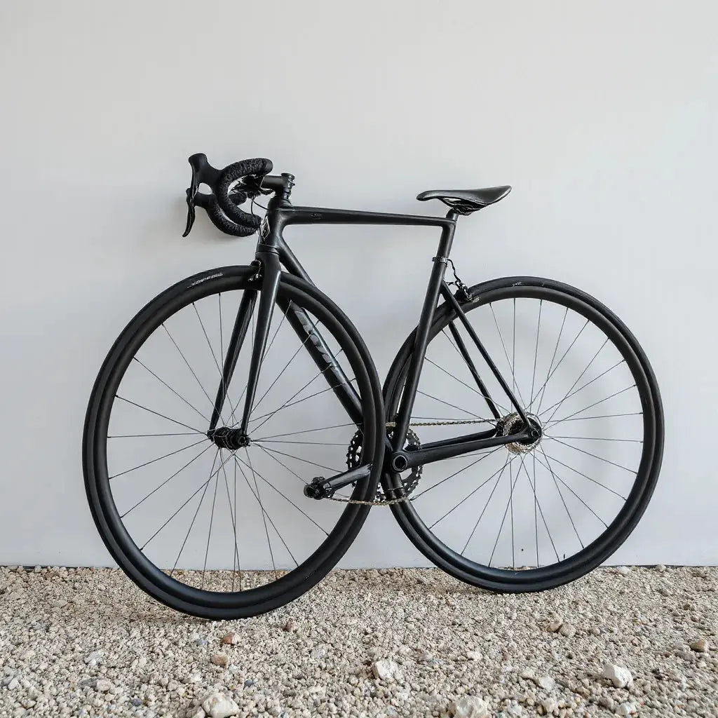 Carbon gravel wheelset with visible rim texture and tires against a neutral background